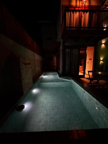 an empty swimming pool in a dark room at Marlim-azul Loft in Prado