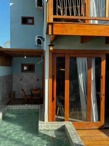 a house with a glass door and a patio at Marlim-azul Loft in Prado