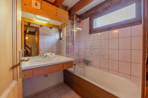 une salle de bain avec un lavabo, une baignoire et un miroir dans l'établissement Corniche B21 - Snow and Trek - Morzine, à Morzine