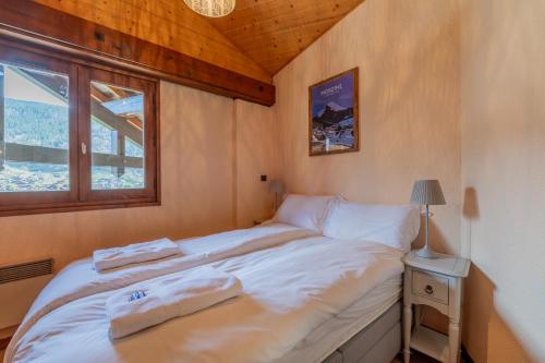 une chambre avec un lit avec deux serviettes dessus dans l'établissement Corniche B21 - Snow and Trek - Morzine, à Morzine