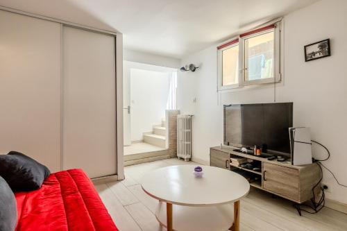 un salon avec un canapé, une télévision et une table dans l'établissement Le coin du Bonheur au port de Nice !, à Nice