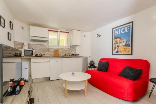 un salon avec un canapé rouge et une table dans l'établissement Le coin du Bonheur au port de Nice !, à Nice