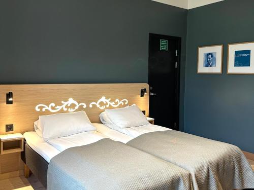 a bedroom with two beds with white sheets at Hotell Bondeheimen in Oslo