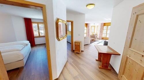 a bedroom with a bed and a table in a room at Schweizerhaus Apartments in Maloja