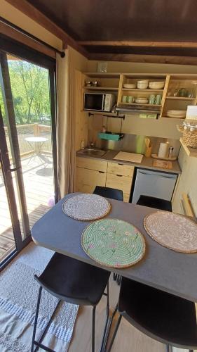 a kitchen with a table and chairs in a trailer at Logde premium Cagire in Aspet