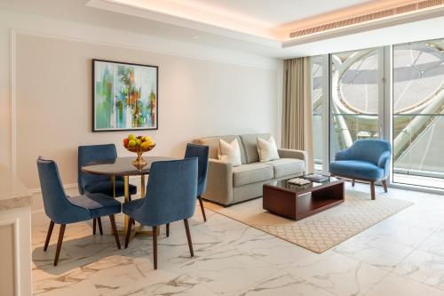 a living room with a couch and a table and chairs at Cheval Maison - Expo City Dubai in Dubai
