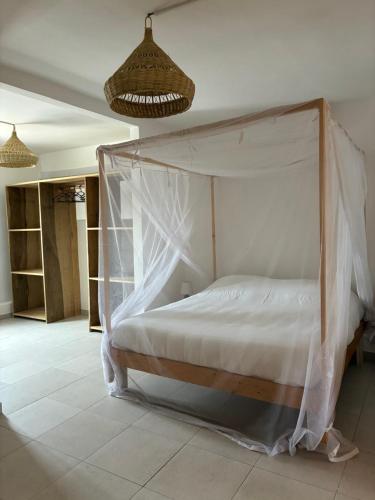 a bed with a canopy in a room at La Cabane du Pêcheur Atlantic Evasion in Dakar