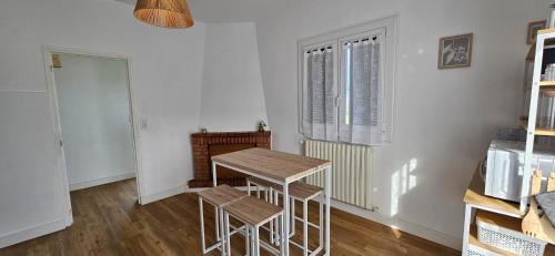 une cuisine avec une table et des tabourets dans une pièce dans l'établissement VIA ROMANA- Clim- à 5mn de la plage de sable, à Prunelli-di-Fiumorbo