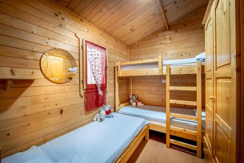a bedroom with two bunk beds in a wooden cabin at La Mimosa Camping in Fano