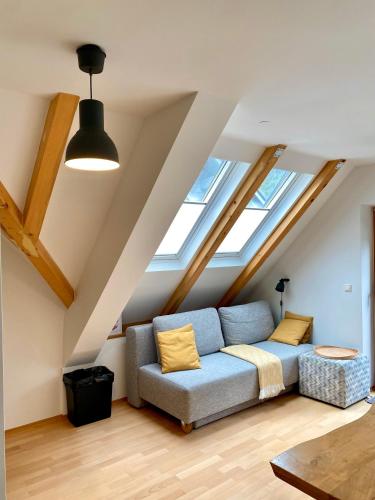 un soggiorno con un divano blu in una soffitta di Apartment Iris a Bohinj