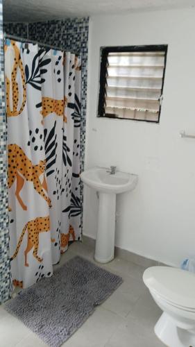 a bathroom with a shower curtain and a sink at Villa Rosa Bella Perfect for families or groups in Palmar de Ocoa