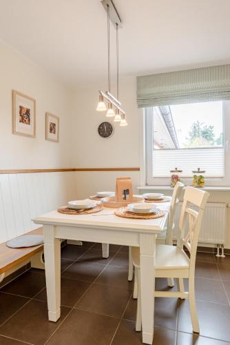 a white table and chairs in a kitchen with a window at Südstern EG, Schwalbenweg in Südstrand