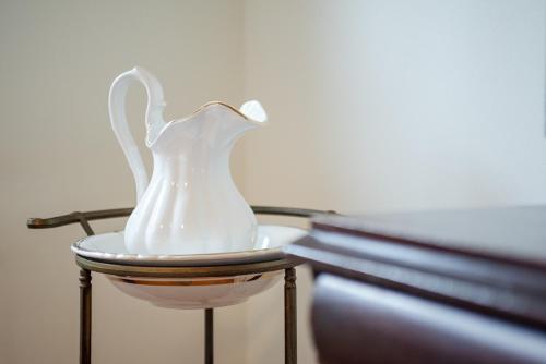 a white vase sitting on a stool next to a bed at Südstern EG, Schwalbenweg in Südstrand