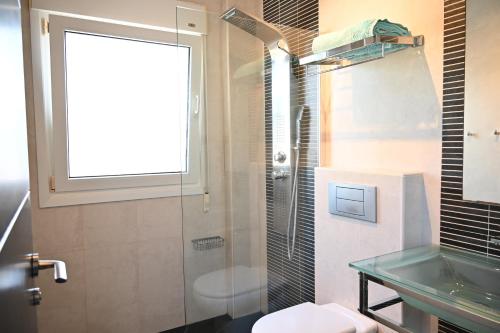 Los UrrutiasにあるVilla La Mariposaのガラスのシャワーと洗面台を備えたバスルーム