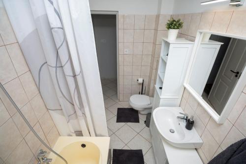 a small bathroom with a toilet and a sink at Becky Apartman in Komló