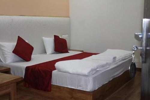 a bedroom with two beds with red and white pillows at Black Diamond Hotel & Spa in Zirakpur