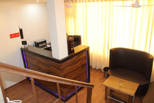 a living room with a black chair and a table at Black Diamond Hotel & Spa in Zirakpur