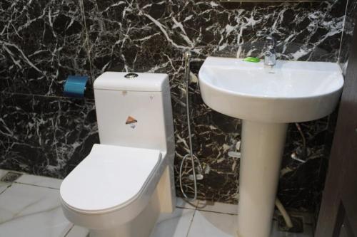 a bathroom with a white toilet and a sink at Black Diamond Hotel & Spa in Zirakpur