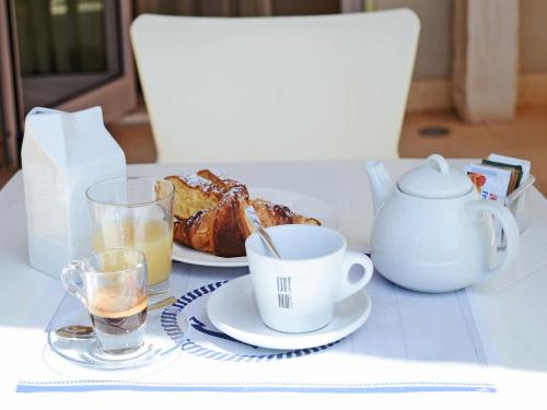 a table with a cup of coffee and a plate of bread at Hotel Mar & Sol in Punta Secca