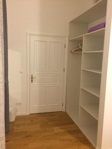a closet with a white door and shelves at Aurelia Rooms in Mostar
