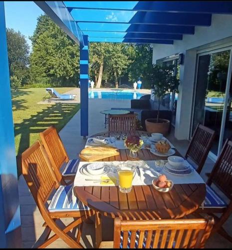 une table en bois avec des assiettes de nourriture sur une terrasse dans l'établissement Riad Landais, à Bénesse-Maremne