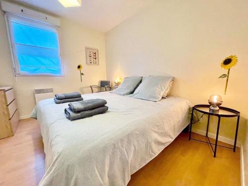 Un dormitorio con una gran cama blanca con almohadas. en Terrasse de l'aber Roscoff, en Roscoff