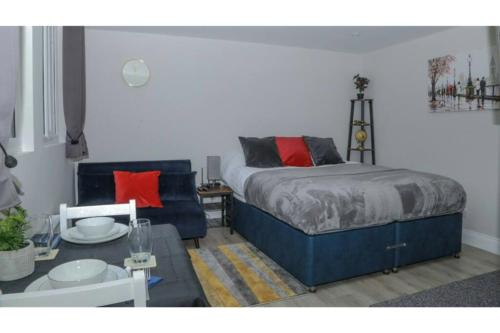 a bedroom with a bed and a couch and a table at StayZo - Crofton Park - Central London refurbished Studio in London