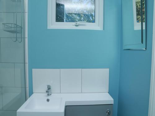 a bathroom with a white sink and a mirror at StayZo - Crofton Park - Central London refurbished Studio in London