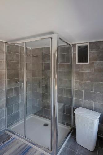 une douche avec une cabine en verre dans une salle de bain dans l'établissement La Tannerie - St Antonin Noble Val, à Espinas