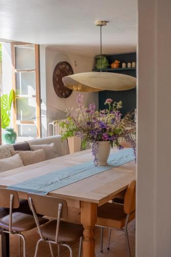 une table de salle à manger avec un vase de fleurs dessus dans l'établissement La Tannerie - St Antonin Noble Val, à Espinas