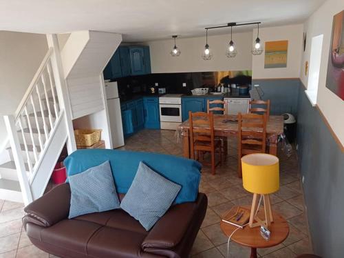 un salon et une cuisine avec un canapé et une table dans l'établissement Les Gîtes du Triskell, Gîte de l'AIR, à Sainte-Tréphine