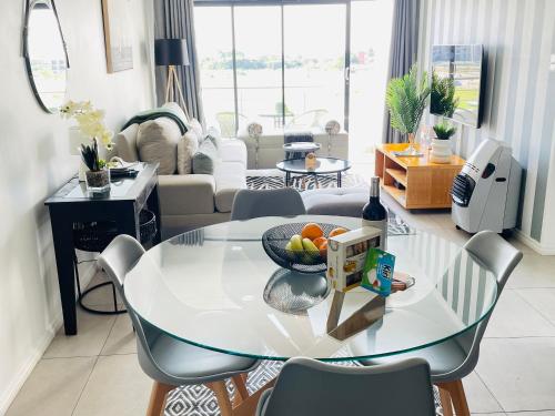 ミッドラントにある2Bedroom Luxury Family Living Space in Midrandのリビングルーム(フルーツボウル付きのガラステーブル付)