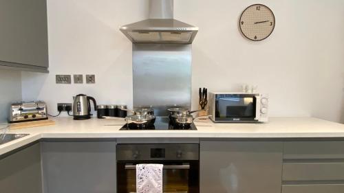 a kitchen with a stove and a microwave at De Parys Premier Lodge 3 in Bedford in Bedford