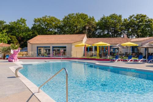 une piscine dans un complexe hôtelier avec un rose dans l'établissement Camping maeva Escapades Le Bois Joli, à Bois-de-Cené