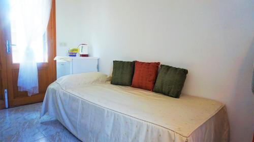 a bed with four pillows on it in a room at Can Tassi in Porto Cristo
