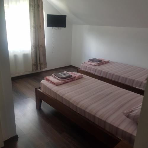 two twin beds in a room with a window at Pensiunea Ovidiu in Beclean