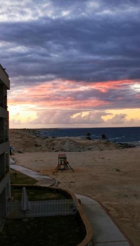 a view of the beach at sunset with a picnic table at Sea Front Zen Chalet Families Only in Marsa Matruh