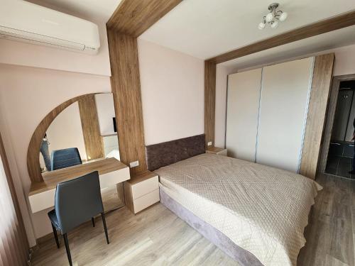 ヴァルナ・シティにあるEuroproperties SkyLine Apartmentsのベッドと机と鏡のある寝室