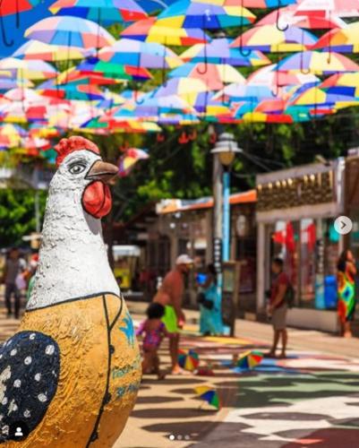 a wooden statue of a chicken with umbrellas at MALIA MURO ALTO STUDIO 300m DO MAR in Porto De Galinhas