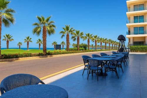 a row of tables and chairs next to a road with palm trees at Private Chalet with Relaxing Outdoor Area in Port Said