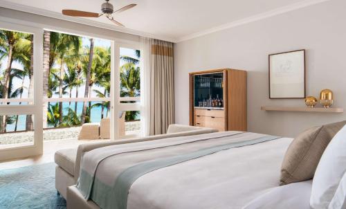 a bedroom with a large bed and windows with a view at One&Only Le Saint Géran, Mauritius in Belle Mare