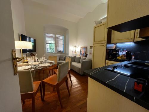 une cuisine et un salon avec une table et des chaises dans l'établissement Appartement Ombragé 44m2 Riviera Palace Belle-Epoque, Restomod et Literie Prestige, à Menton