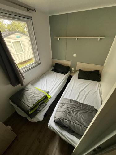 deux lits dans une petite pièce avec une fenêtre dans l'établissement Ma Parenthèse Ardéchoise, à Ruoms