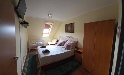 a small bedroom with a bed and a television at TüzesVíz APARTMAN in Egerszalók