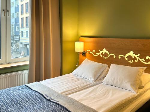 a bed in a room with a window at Hotell Bondeheimen in Oslo