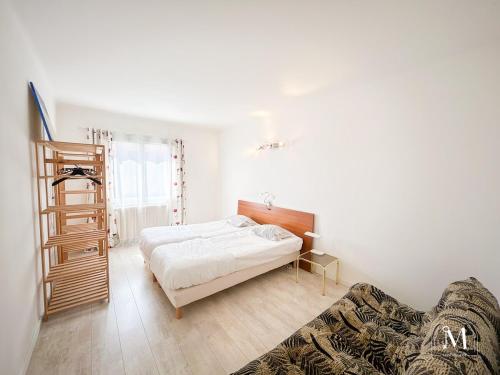 une chambre avec un lit et un canapé dans l'établissement Spacieux T3 avec parking au coeur de Sanary, à Sanary-sur-Mer