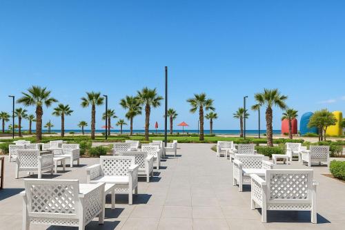 a row of white benches at the beach at Private Chalet with Relaxing Outdoor Area in Port Said