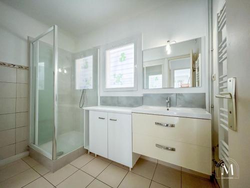 une salle de bain blanche avec une douche et un lavabo dans l'établissement Spacieux T3 avec parking au coeur de Sanary, à Sanary-sur-Mer