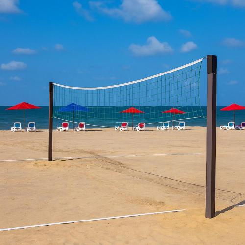 a volleyball net on a beach with chairs and umbrellas at Private Chalet with Relaxing Outdoor Area in Port Said