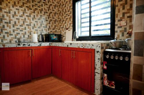 a kitchen with red cabinets and a black stove at Chic villa with pool in Kribi